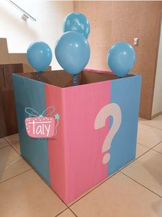 a box that has balloons in it with a question mark on the front and bottom