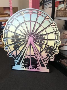 a ferris wheel with palm trees in the background on a black countertop next to a framed photograph