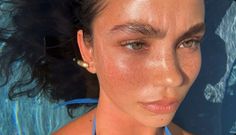 a woman with freckles on her face and sunburned skin, wearing a blue halter top