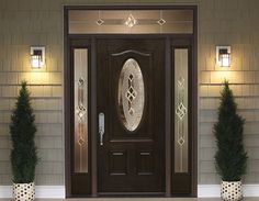 a front door with two potted plants next to it and lights on the side