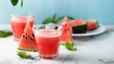 watermelon juice in a glass next to slices of watermelon on a plate