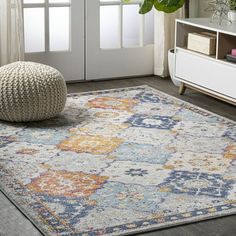 an area rug with various colors and patterns on the floor in front of a door