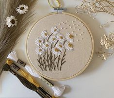 a close up of a cross stitch pattern with scissors and flowers in the hoop next to it