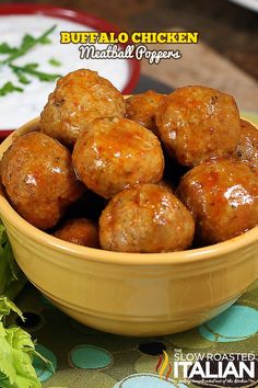 a yellow bowl filled with meatballs next to some lettuce on a table