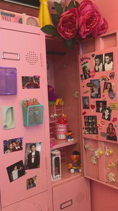 a pink locker with pictures and magnets on the doors is next to a bouquet of flowers