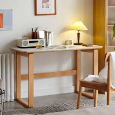 a wooden desk with a lamp on it next to a radiator and chair