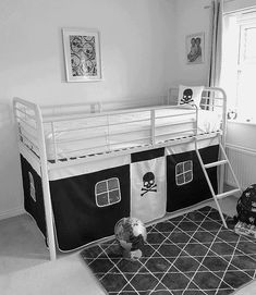 a black and white photo of a child's room with bunk beds, rugs and toys