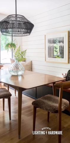 a dining room table with chairs and pictures on the wall