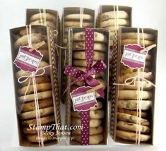 some cookies are wrapped in brown paper and tied with pink ribbon, sitting next to each other