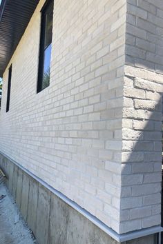 a white brick building with a black window