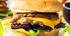 a cheeseburger with lettuce and other toppings sits on a table