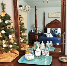 a bedroom with a christmas tree in the corner and other items on a tray next to it