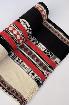 a black, white and red blanket laying on top of each other