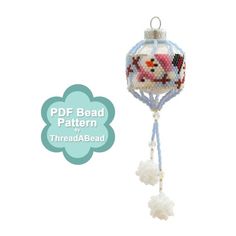 a beaded ornament with a bear on it's head hanging from a string