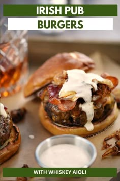 two burgers on buns with white sauce and bacon