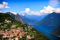 an aerial view of a village on the side of a mountain with mountains in the background