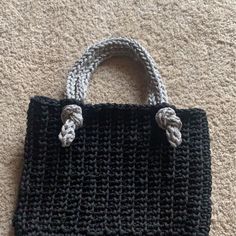 a crocheted black and white purse laying on the floor