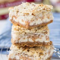 three dessert bars stacked on top of each other with coconut flakes all over them