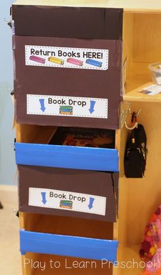 an open book shelf with books on it and some other items in the bins