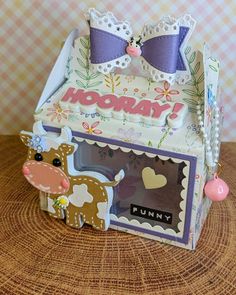 a cardboard box with two bow ties on top of it, and the word hooray is in front of an image of a cow