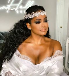 a woman with long hair wearing a white dress and tiara, posing for the camera