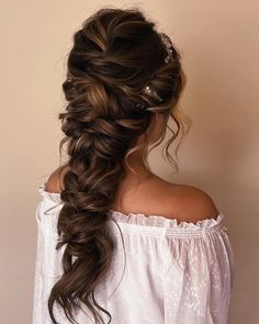 a woman with long hair in a half - up braid, wearing a white blouse