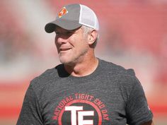 a close up of a man wearing a hat and t - shirt on the field