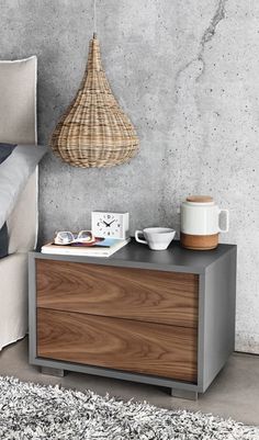 a bedroom with a bed, nightstand and basket hanging from the ceiling in front of it