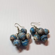 two pairs of blue and white glass bead earrings on a white surface with silver earwires