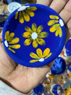 a hand holding a blue and yellow painted object