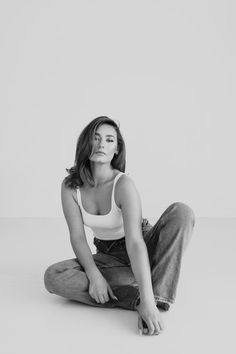 a black and white photo of a woman sitting on the floor