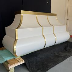 a large white and gold fireplace in the middle of a room with black rugs on the floor