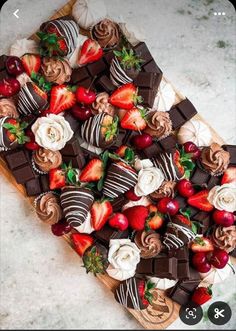 chocolate covered strawberries and other desserts on a wooden platter