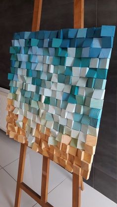 an easel made out of wooden blocks with blue and white squares on the top