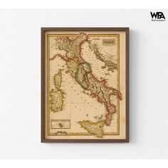 an old map hanging on the wall in front of a white wall with a wooden frame