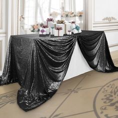 a table covered in black cloth with presents on it