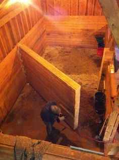 a person working in an enclosed area with wooden walls and beams on either side of the building