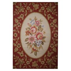 a red and white rug with flowers in the center on top of it's border