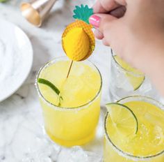 two glasses filled with lemonade and garnished with a pineapple