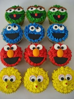 twelve cupcakes decorated in the shape of sesame street characters