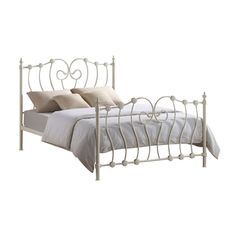 a white metal bed with two pillows on it