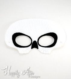 a white mask with black eyes on a white surface