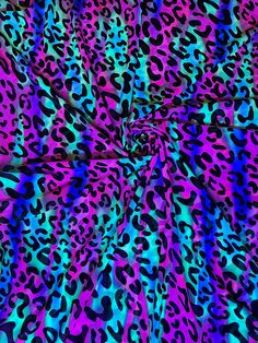 an animal print fabric with blue, pink and purple colors on it's surface