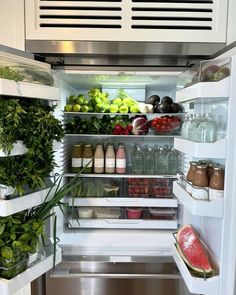 an open refrigerator filled with lots of fresh fruits and vegetables, including watermelon