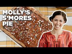 there is a woman smiling next to a large piece of pie with sprinkles on it