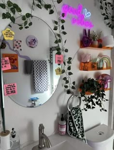 a bathroom with a mirror, sink and plants on the wall next to each other