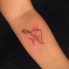 a small tattoo on the arm of a woman's left arm with a red and black outline