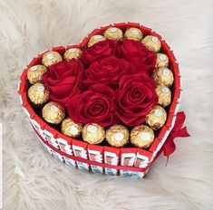 a heart shaped box filled with chocolates and roses