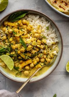 a bowl filled with rice, chickpeas and garbanzo beans next to limes