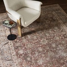 a chair sitting on top of a rug next to a table